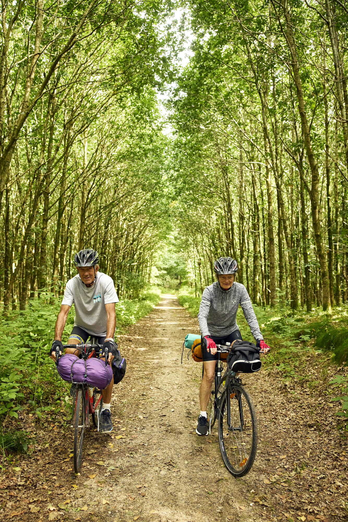 Ældre mand og dame cykler i naturen