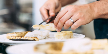 Nærbillede af tallerken med fisk, der anrettes