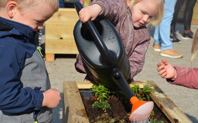 Børnehavebørn vander blomster på Sæby Ældrecenter