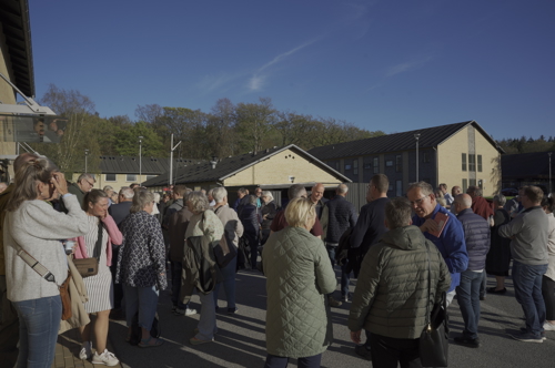 Fremmødte taler ude foran Sergentskolen i solskin