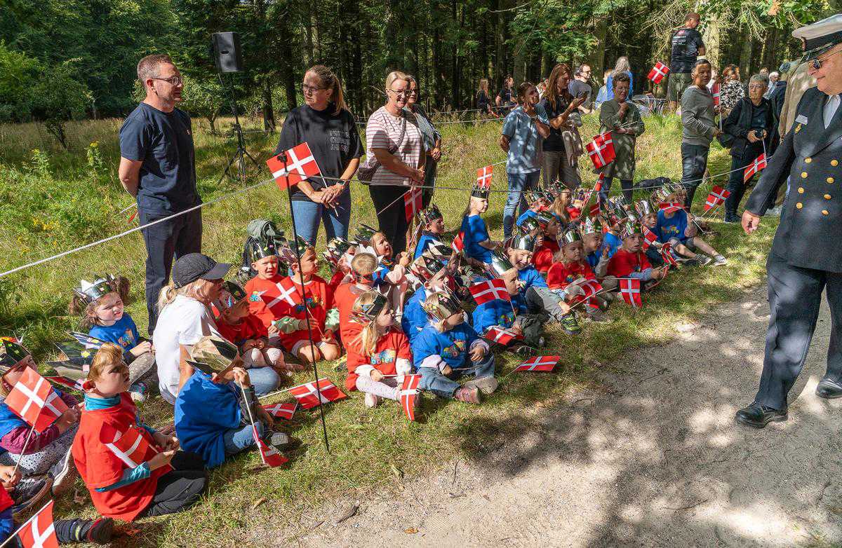 Glade børn med flag tager imod kongeparret i Bangsbo Dyrehave